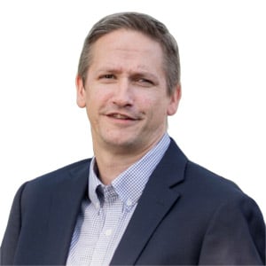 Professional man in a suit and checkered shirt, smiling at the camera, isolated on a white background.