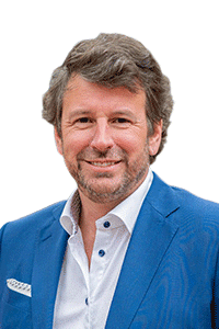 Man in a blue suit smiling against a white background.